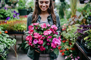 Girl holding flowers in greenhouse